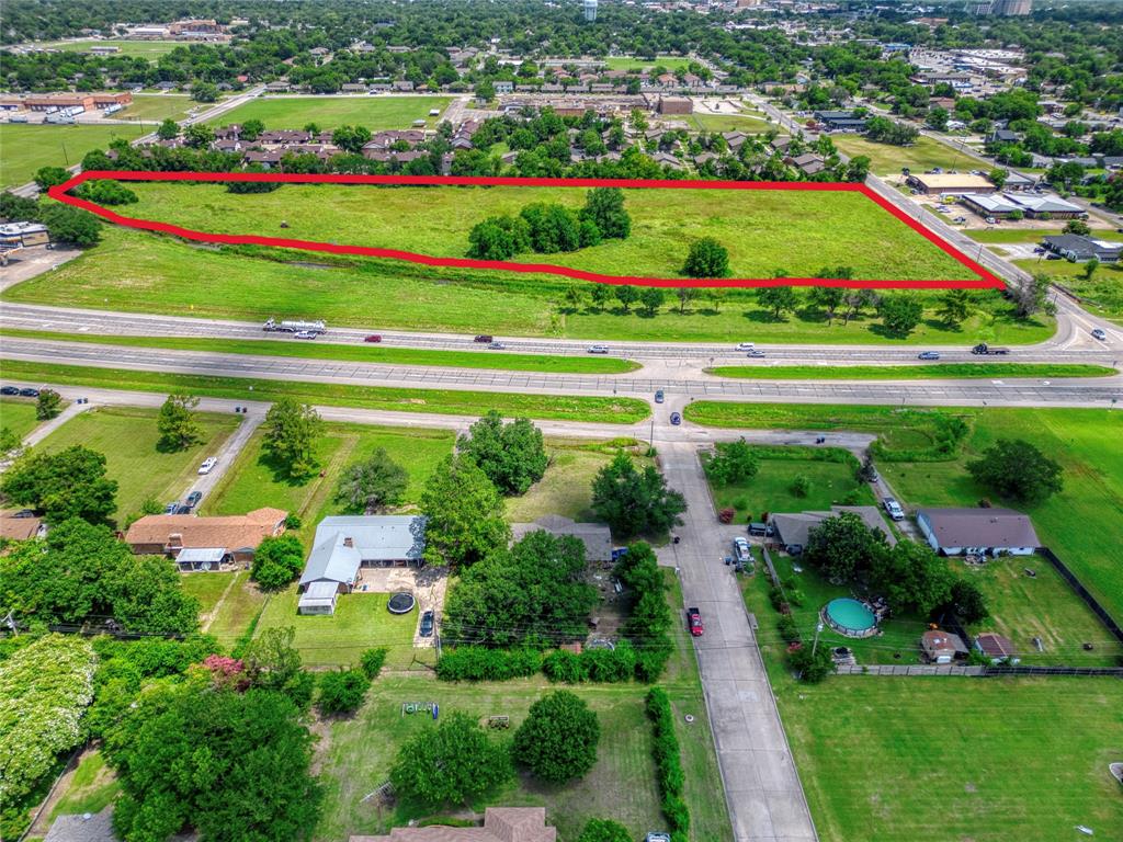 Expansive vacant land parcel featuring significant open acreage and clusters of mature trees