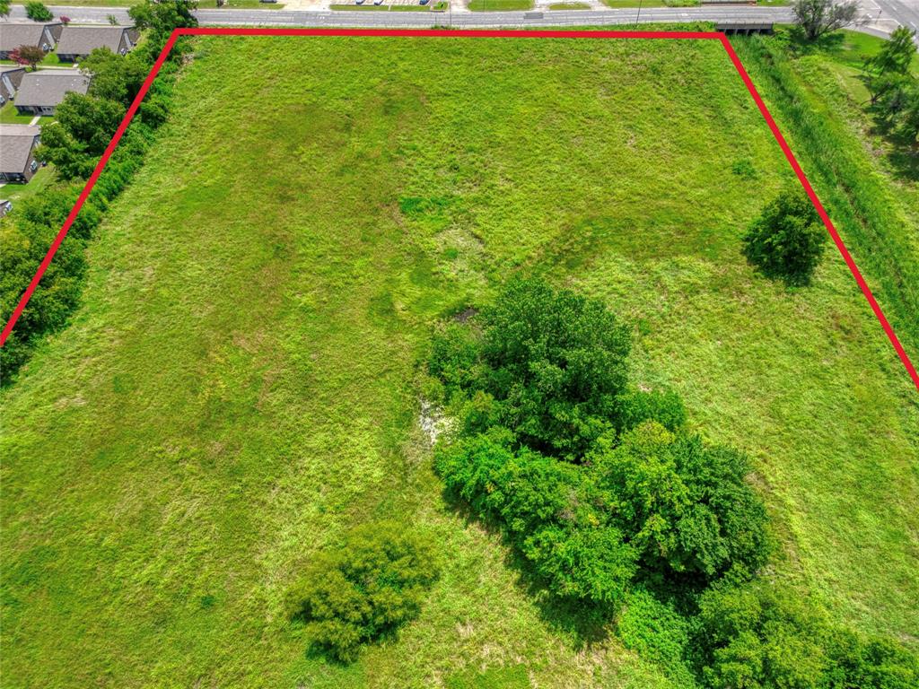 Expansive parcel of land featuring open grassy terrain and mature trees