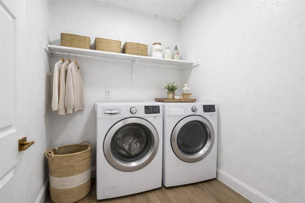 Dedicated laundry space featuring wood-finish flooring, white walls, and a built-in overhead shelf with integrated garment rod