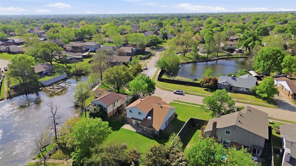 Aerial perspective of a suburban neighborhood featuring a residential lot with direct water frontage, a spacious backyard, and mature trees Aerial perspective of a suburban neighborhood featuring a residential lot with direct water frontage, a spacious backyard, and mature trees