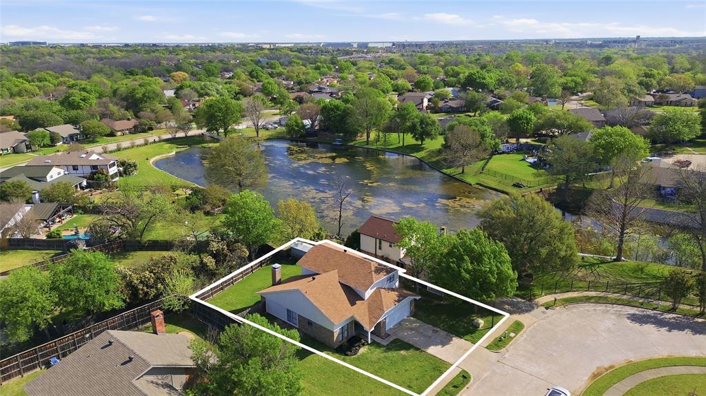Aerial perspective of a multi-level residence featuring a brick and siding exterior, a composition shingle roof, an attached garage, and a fenced backyard Aerial perspective of a multi-level residence featuring a brick and siding exterior, a composition shingle roof, an attached garage, and a fenced backyard