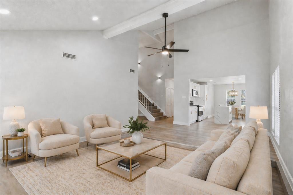Vaulted ceilings, wood-finish flooring, recessed lighting, matte black ceiling fan, and stairwell with a wooden handrail Vaulted ceilings, wood-finish flooring, recessed lighting, matte black ceiling fan, and stairwell with a wooden handrail