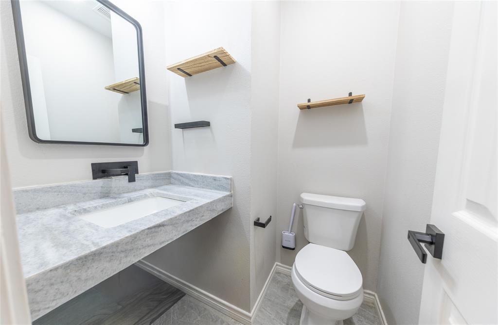Half bath off of den next to a separate utility room.