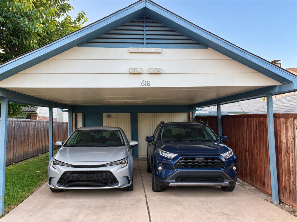 Covered two-car carport featuring a gabled roofline, slatted ventilation detail, and a concrete parking surface