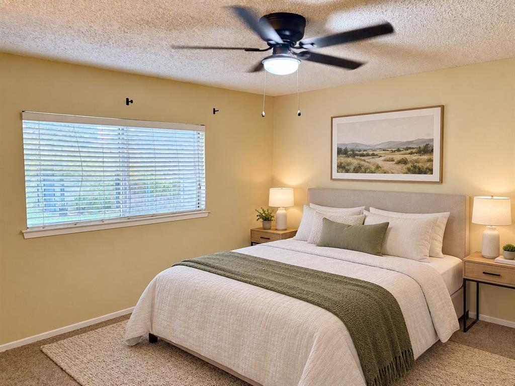 Room featuring a matte black ceiling fan with an integrated light fixture, neutral wall color, and large horizontal window with slatted blinds