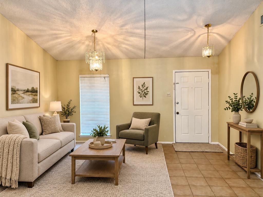 Entry area featuring ceramic tile flooring, dual glass and gold-tone pendant lighting, and a six-panel exterior door