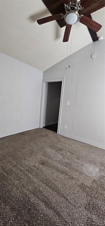 Vaulted ceiling featuring a dark wood-finish ceiling fan with integrated lighting and wall-to-wall carpeting