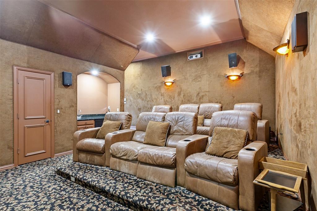 Fully equipped Media Room with projection system, tiered seating, wet bar, and suede walls that enhance the intimate viewing experience.
