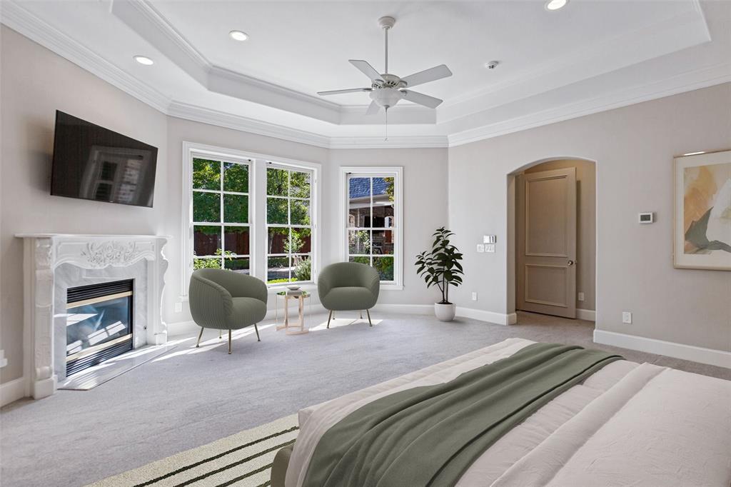 The Primary Bedroom is a true retreat with a fireplace, seating area, and spectacular views of the pool and yard.