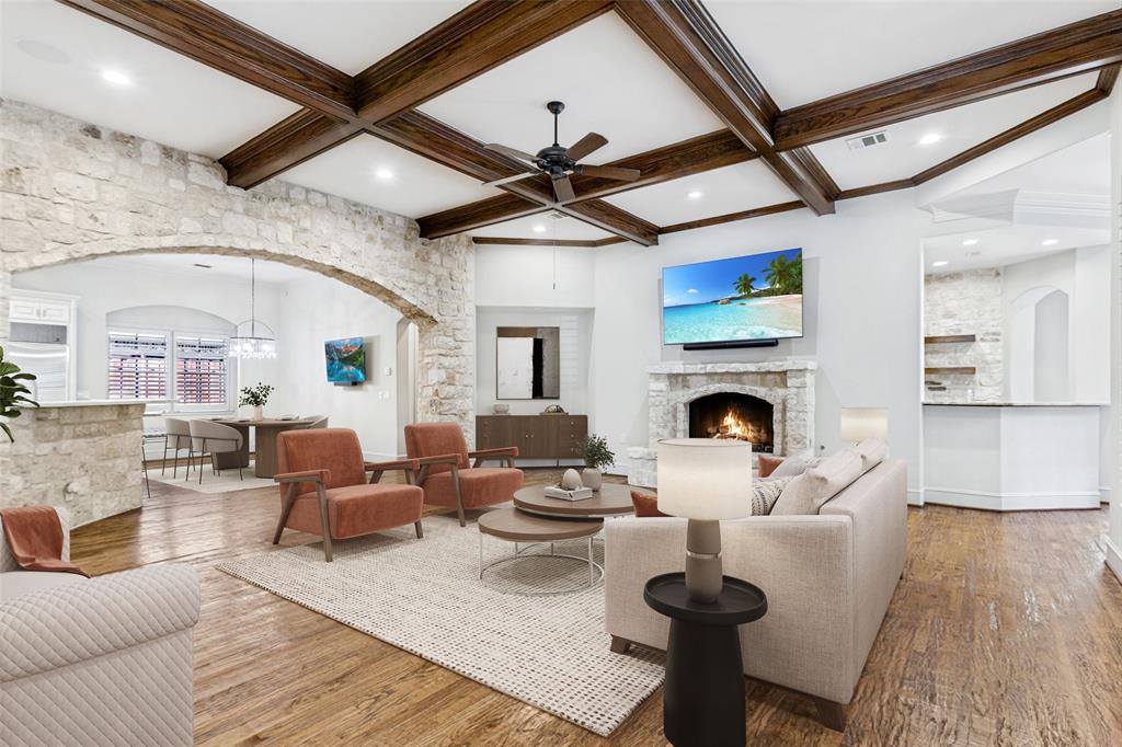 Another view of the Family Room showing the coffered ceiling, fireplace, stone architectural accents, and wet bar to the right.