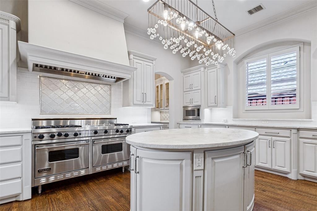 Every chef's dream - a 60 inch Viking Gas Range!  The center task island offers electrical outlets and great storage. Microwave and butler's pantry are beyond.  The large window brings the light in!