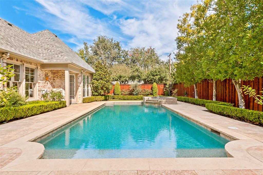 Sparkling linear pool with Pebble Tech finish and raised spa with fountain!
