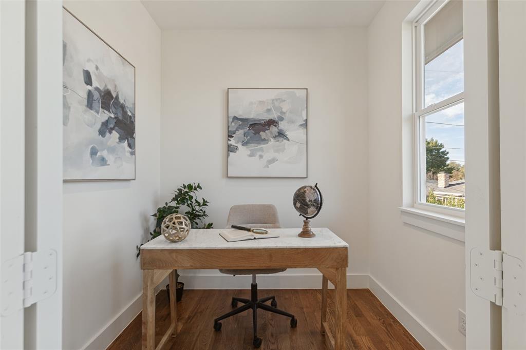 Enclosed room featuring wood-finish flooring, white walls, and a large window