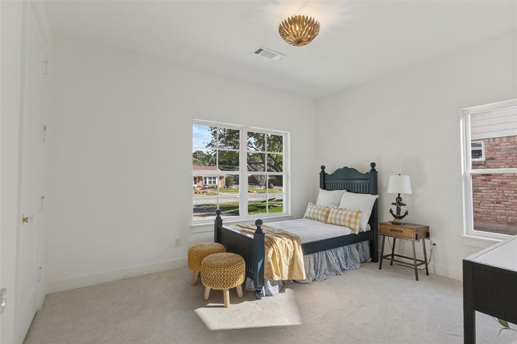 Neutral-toned wall finish, wall-to-wall carpeting, multi-pane windows, and a decorative flush-mount ceiling light fixture