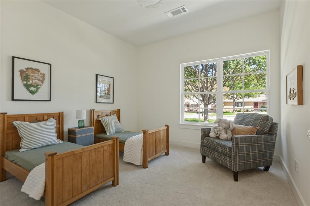 Neutral interior space featuring high ceilings, wall-to-wall carpeting, and a large multi-pane window with exterior greenery