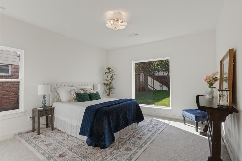 Neutral-toned room featuring expansive windows, neutral wall-to-wall carpeting, and a multi-bulb flush-mount ceiling fixture