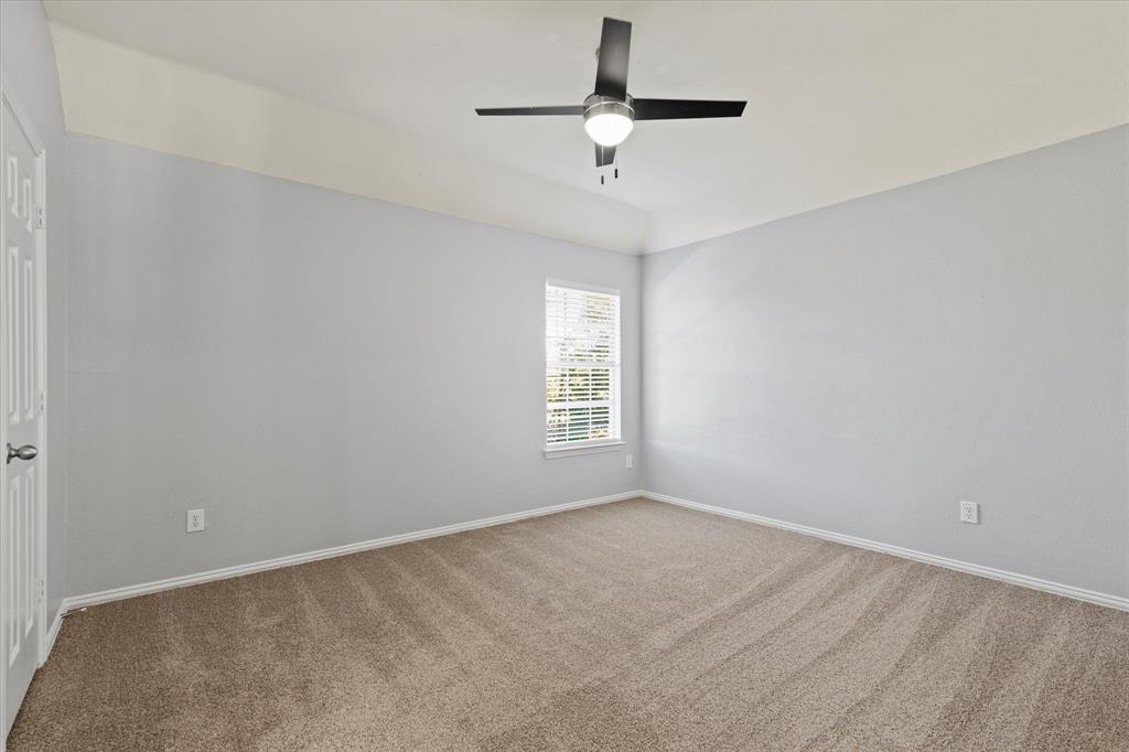 Neutral-toned interior featuring high ceilings, wall-to-wall carpeting, and a modern ceiling fan with integrated lighting