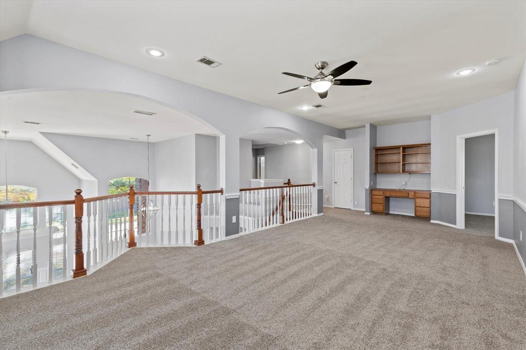 Upstair Living Area. Open-concept interior featuring arched architectural detailing, a wooden handrail with balusters, recessed lighting, a ceiling fan, and built-in wooden cabinetry