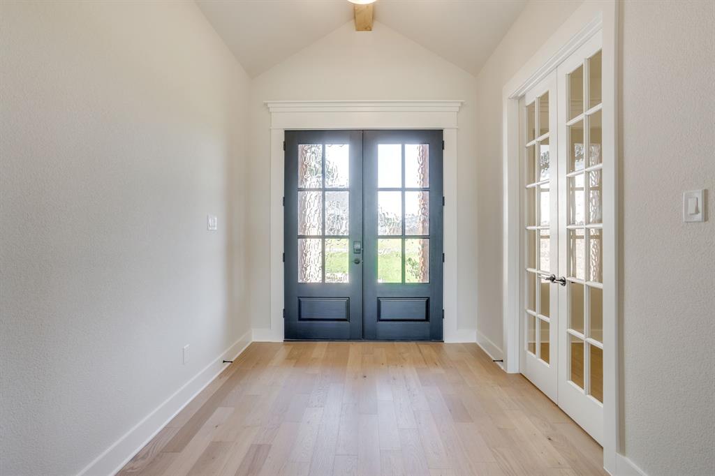 Entryway featuring vaulted ceilings, wood-finish flooring, double-door entrance with glass paneling, and French doors with glass panes