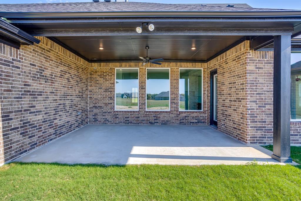 Covered brick patio featuring a concrete floor, recessed ceiling lighting, a built-in ceiling fan, and large rectangular windows