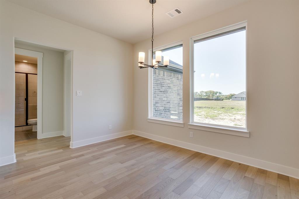 Wood-finish flooring, tall windows, and a multi-light chandelier