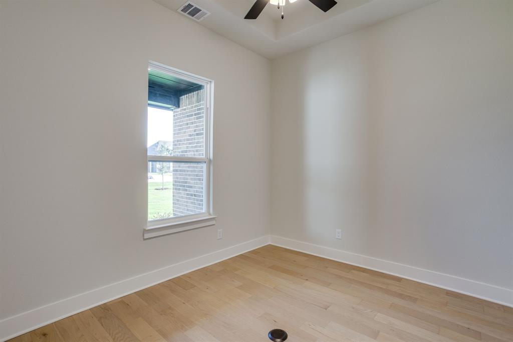 Interior space featuring wood-finish flooring, a coffered ceiling, and a ceiling fan with integrated lighting