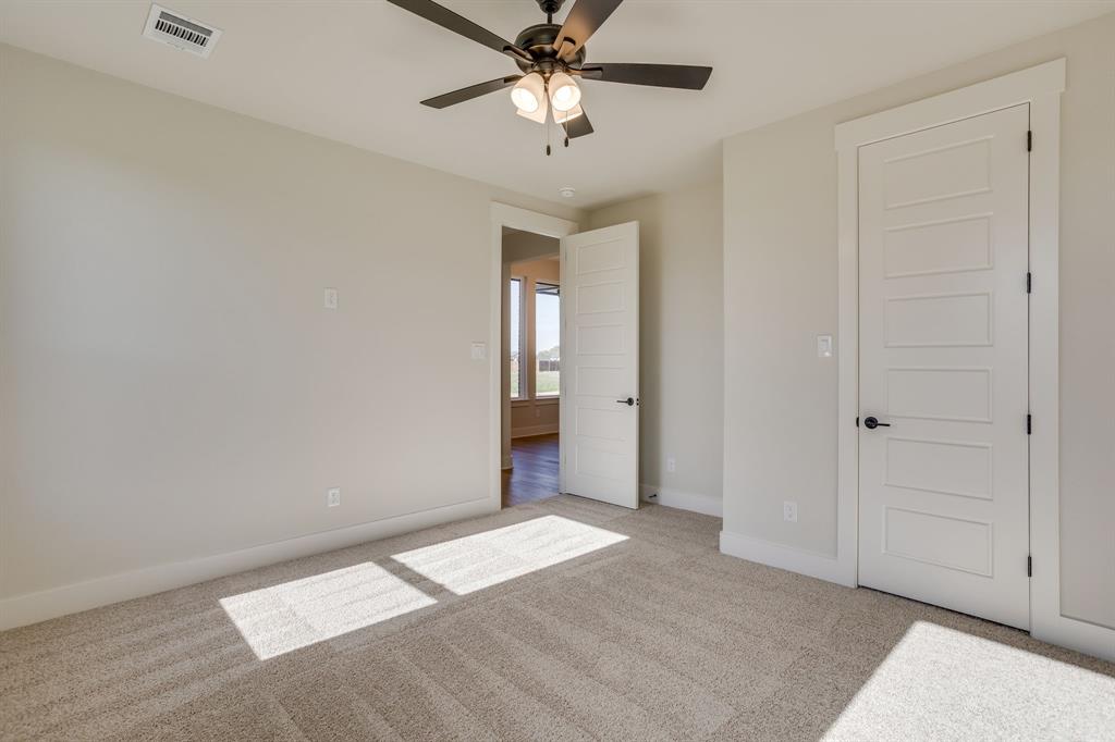 Neutral-toned carpeted flooring, five-panel interior doors, and a ceiling fan with integrated light fixture