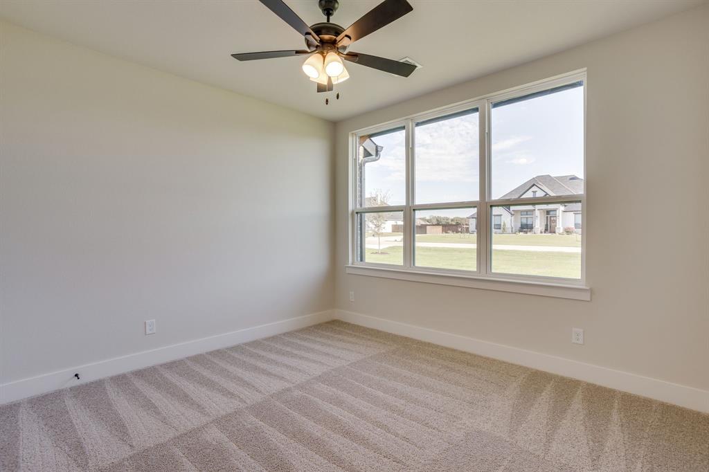 Neutral wall finishes, plush carpeting, multi-pane windows, and a ceiling fan with integrated light fixture