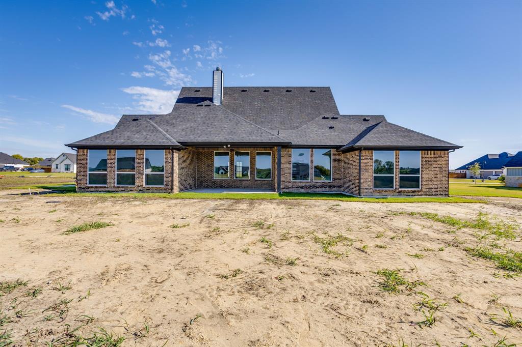 Multi-gabled exterior featuring brick masonry, large pane windows, a covered patio, and a chimney