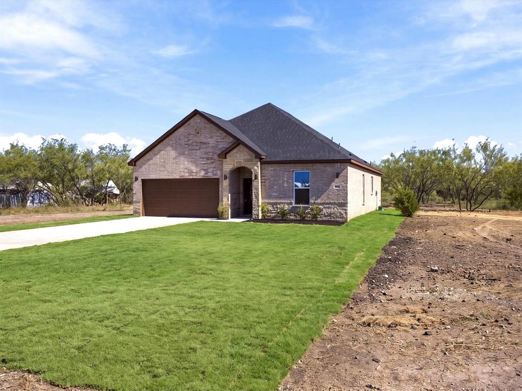 Single-story residence featuring a brick and stone exterior, hipped roof, attached two-car garage, and a concrete driveway