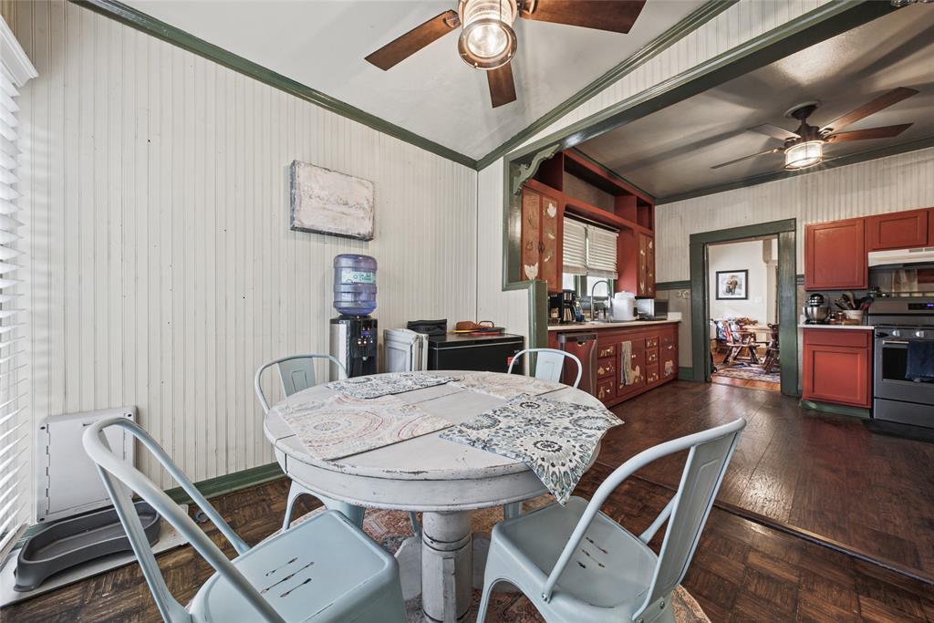 Kitchen area featuring beadboard wall paneling, hardwood flooring, ceiling-mounted paddle fans, and built-in cabinetry