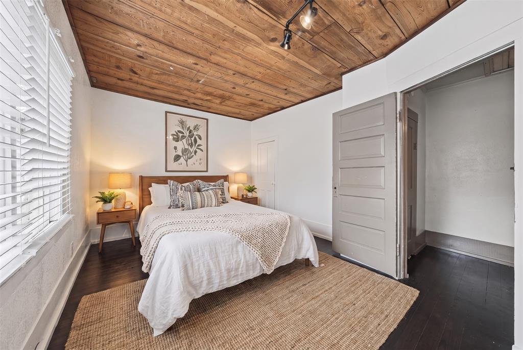 Virtually staged. Wood-plank ceiling, dark wood-finish flooring, and white horizontal blinds