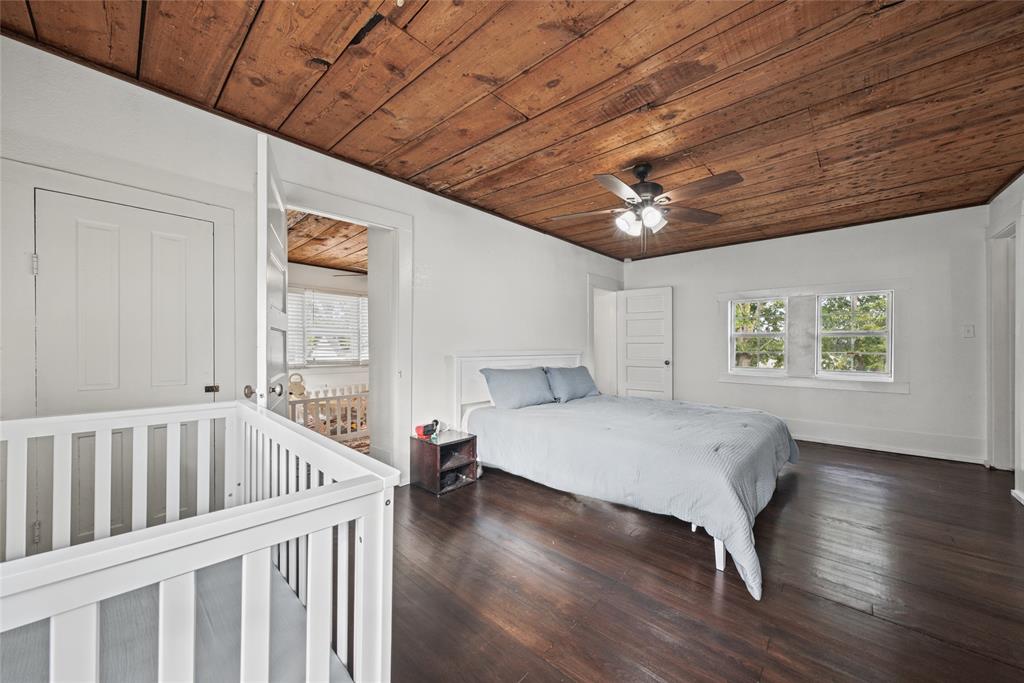 Interior space featuring exposed wood-plank ceiling, dark wood-finish flooring, and multi-pane windows