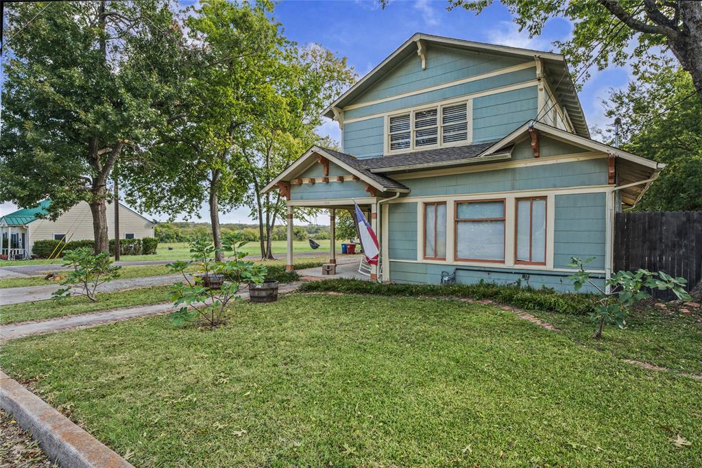 Two-story Craftsman-style exterior featuring horizontal siding, decorative gable brackets, a covered front porch, and multi-pane windows