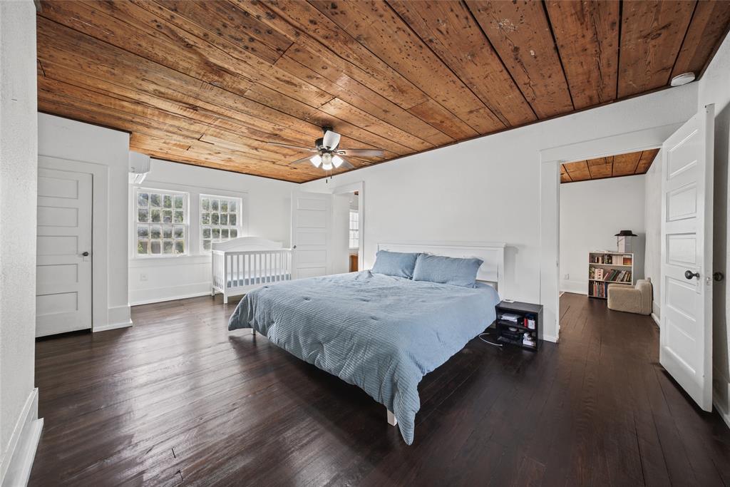 Wood-plank ceiling, dark wood-finish flooring, multi-pane windows, and five-panel interior doors