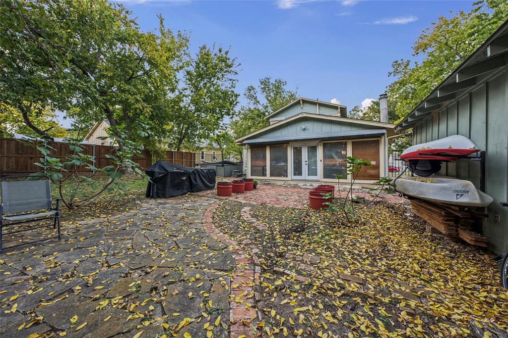 Backyard featuring a flagstone patio with brick border, a separate paved brick area, and tall privacy fencing