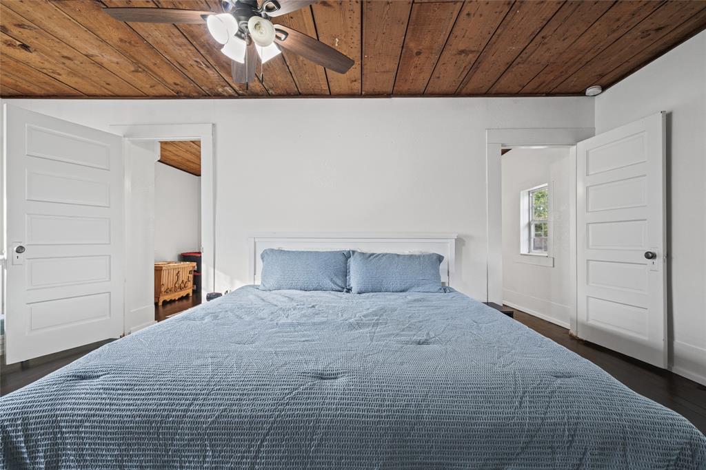 Exposed wood-plank ceiling, five-panel interior doors, and a ceiling-mounted light fixture