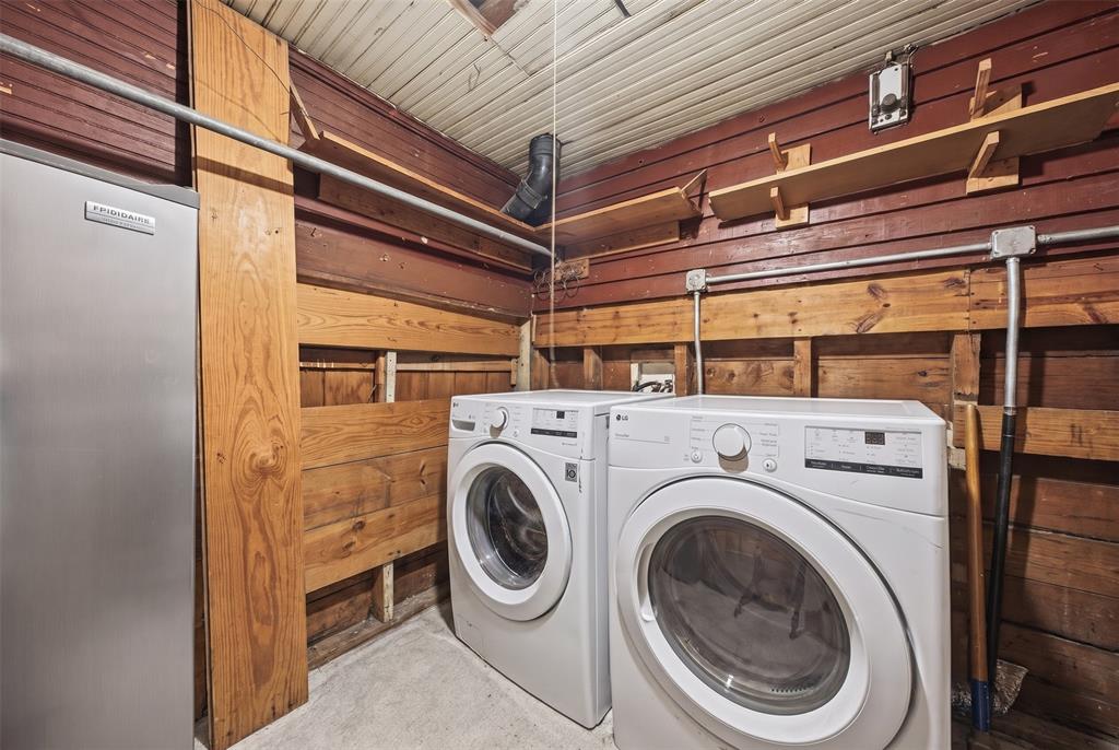 Laundry space featuring exposed wood-plank walls, built-in wooden shelving, and corrugated metal ceiling paneling