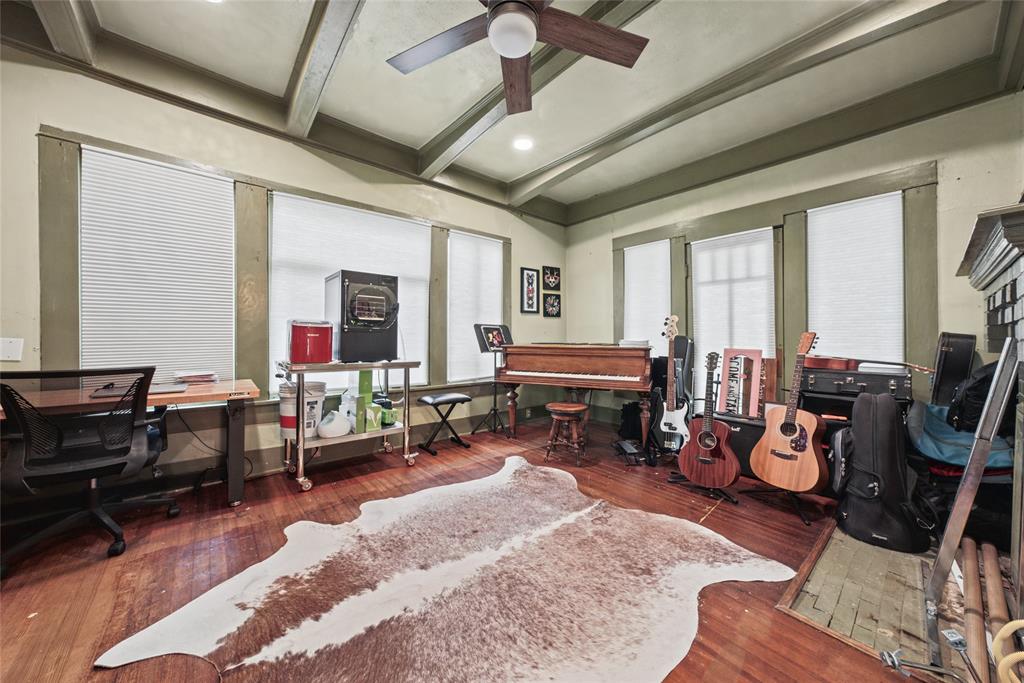 Wood-finish flooring, exposed ceiling beams, and multi-pane windows with integrated blinds