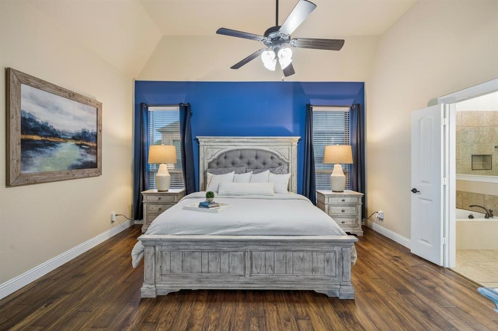 First-floor primary bedroom features wood flooring, generous proportions, updated lighting and an ensuite bath.
