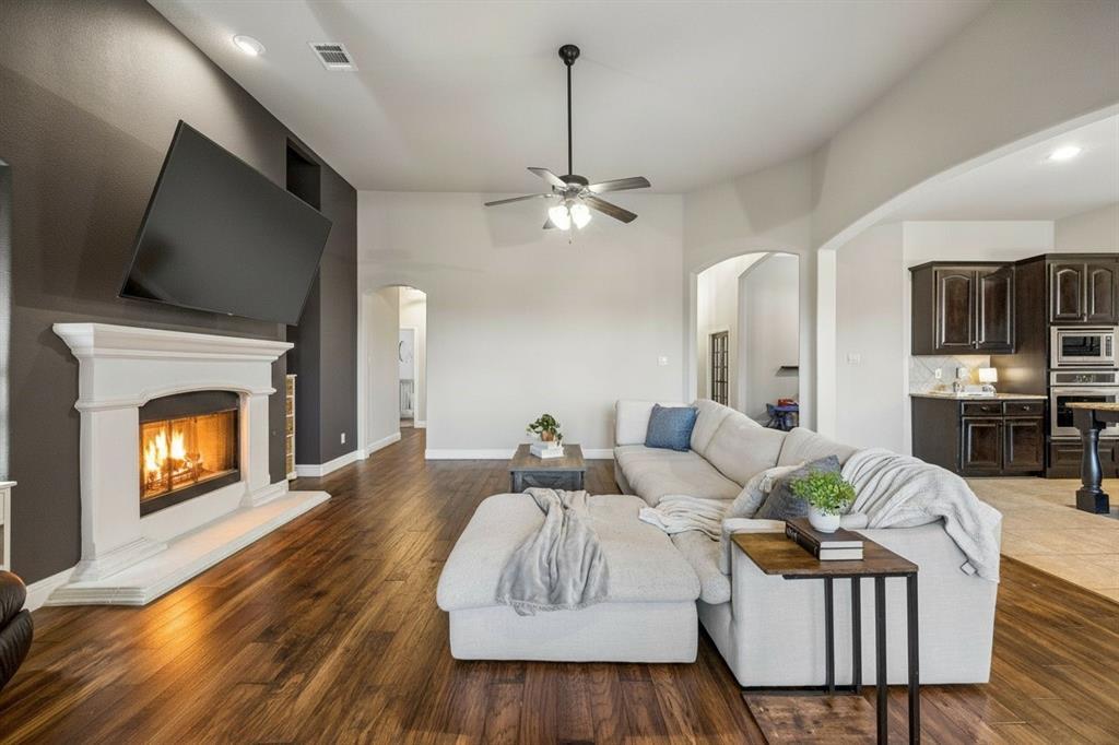 Spacious family room features updated lighting, warm wood flooring, fireplace and an open connection to the kitchen and breakfast area.