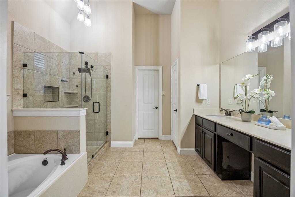 Primary bath features dual vanities, soaking tub and an upgraded frameless glass shower enclosure.