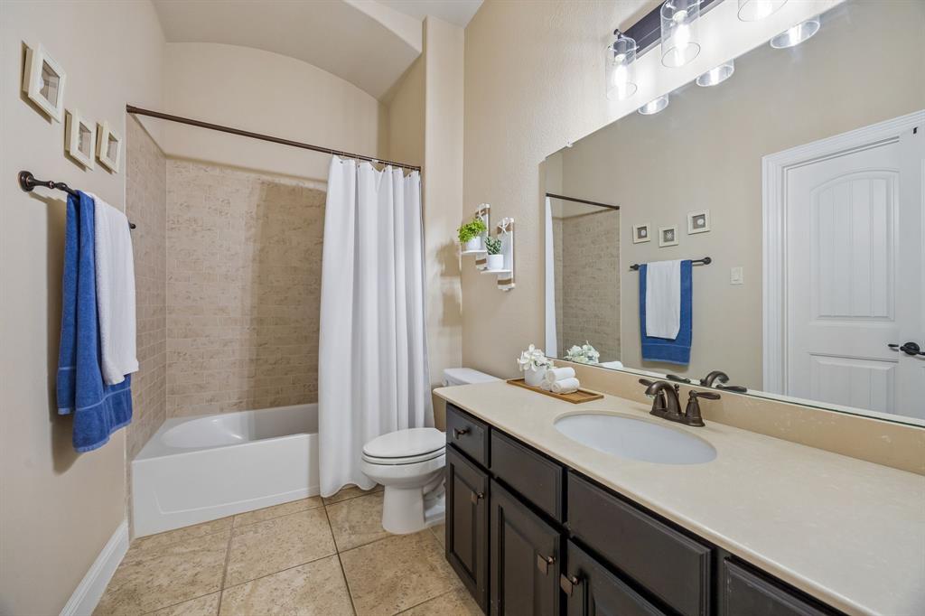Full secondary bathroom serves the first-floor bedrooms and features a dual-sink vanity.