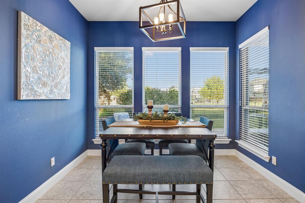 Light-filled breakfast area offers greenbelt views and a colorful accent wall for added character.