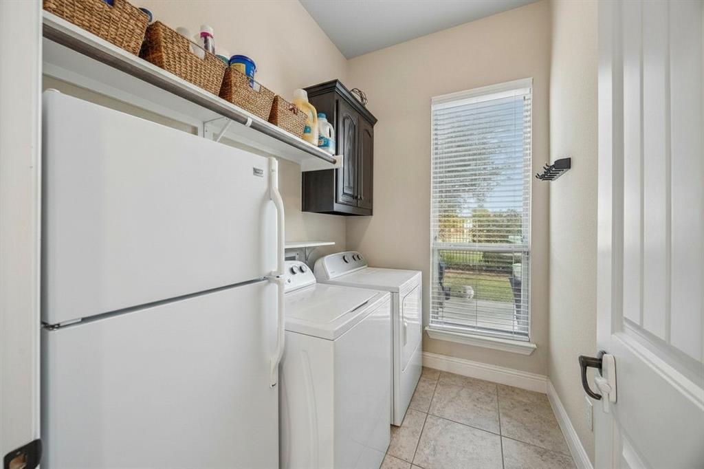 Separate utility room provides dedicated laundry space with built-in cabinetry and room for additional storage.