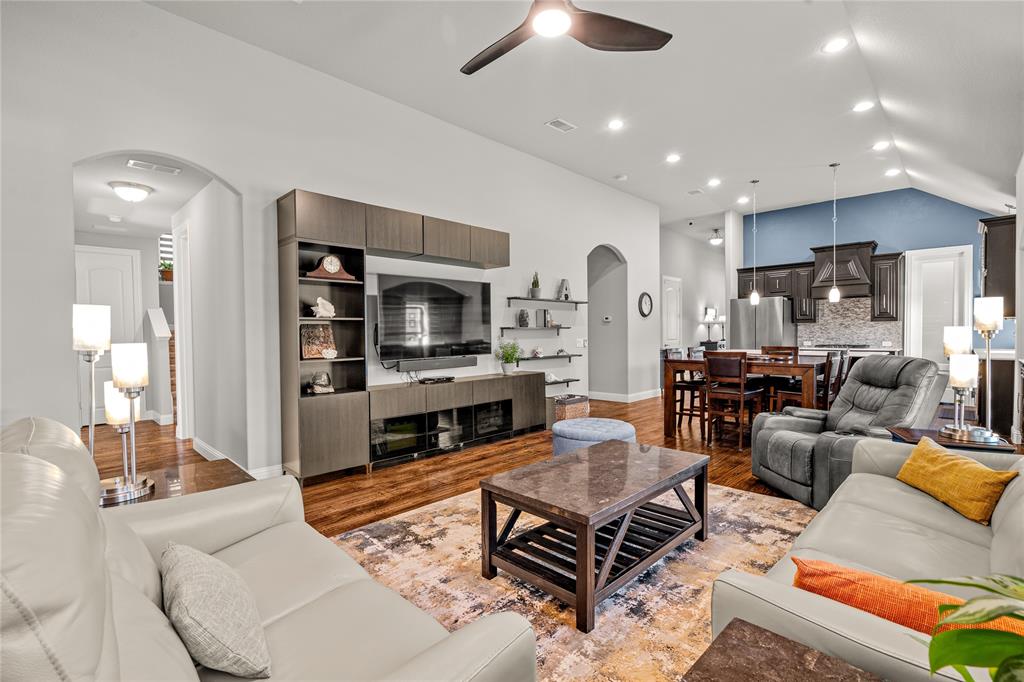 Vaulted ceilings, built-in cabinetry, recessed lighting, wood-finish flooring, and arched doorways
