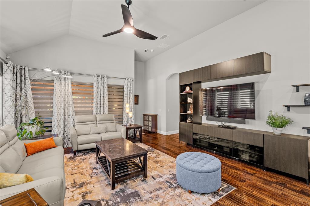 Vaulted ceilings, dark wood-finish flooring, and expansive built-in cabinetry featuring integrated shelving