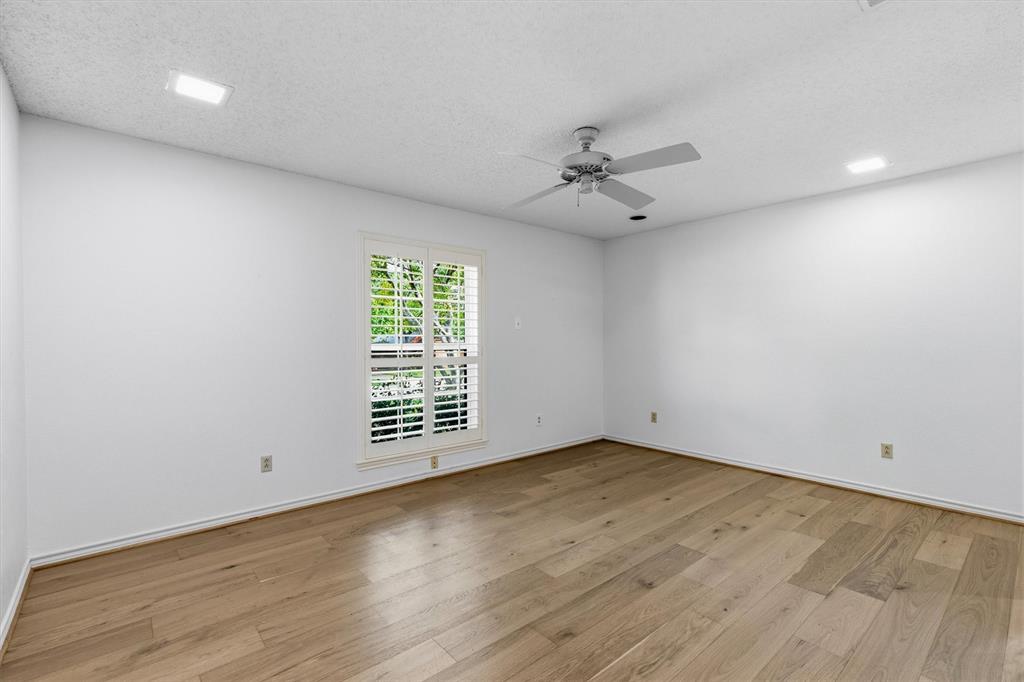 Interior space featuring wood-finish flooring, recessed lighting, a ceiling fan, and a window with plantation-style shutters