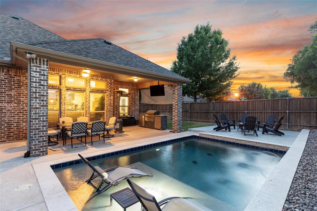 Twilight photo of pool, yard and covered back patio
