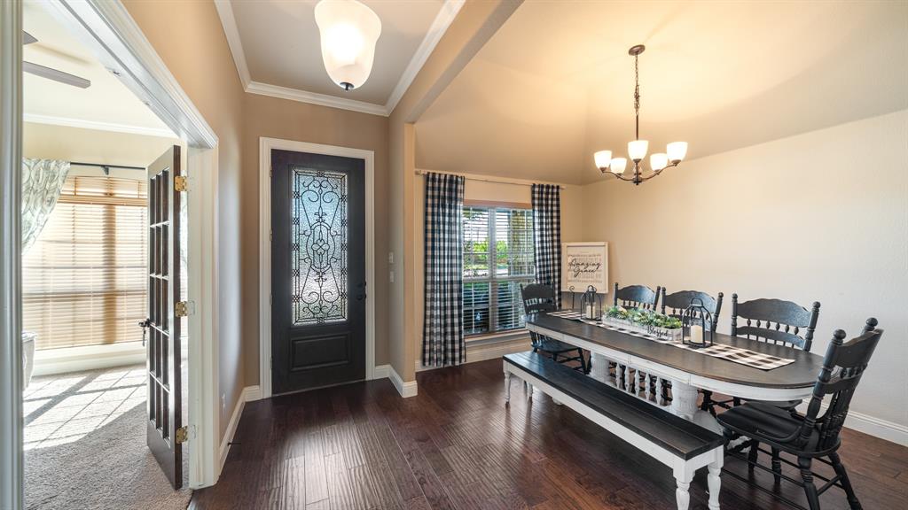 Entry featuring wood-finish flooring, a dark-toned door with decorative glass inlay, arched ceilings, and a multi-light chandelier Entry featuring wood-finish flooring, a dark-toned door with decorative glass inlay, arched ceilings, and a multi-light chandelier